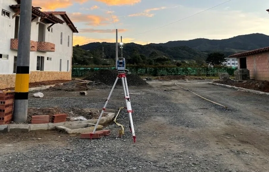 Estación total montada sobre trípode durante un levantamiento en un frente de obra